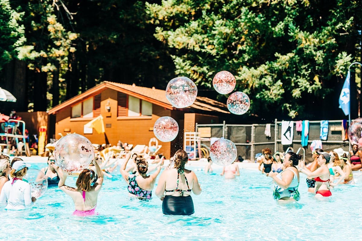 Women in a pool with lots of glittery beach balls being tossed in the air at the compact summer camp in la Honda, CA