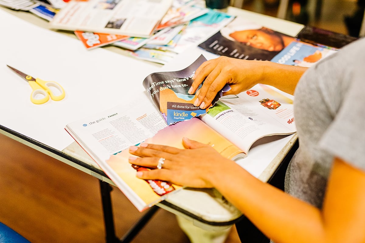 A woman tearing out magazine images to use for her vision board at the compact summer camp in la Honda, CA