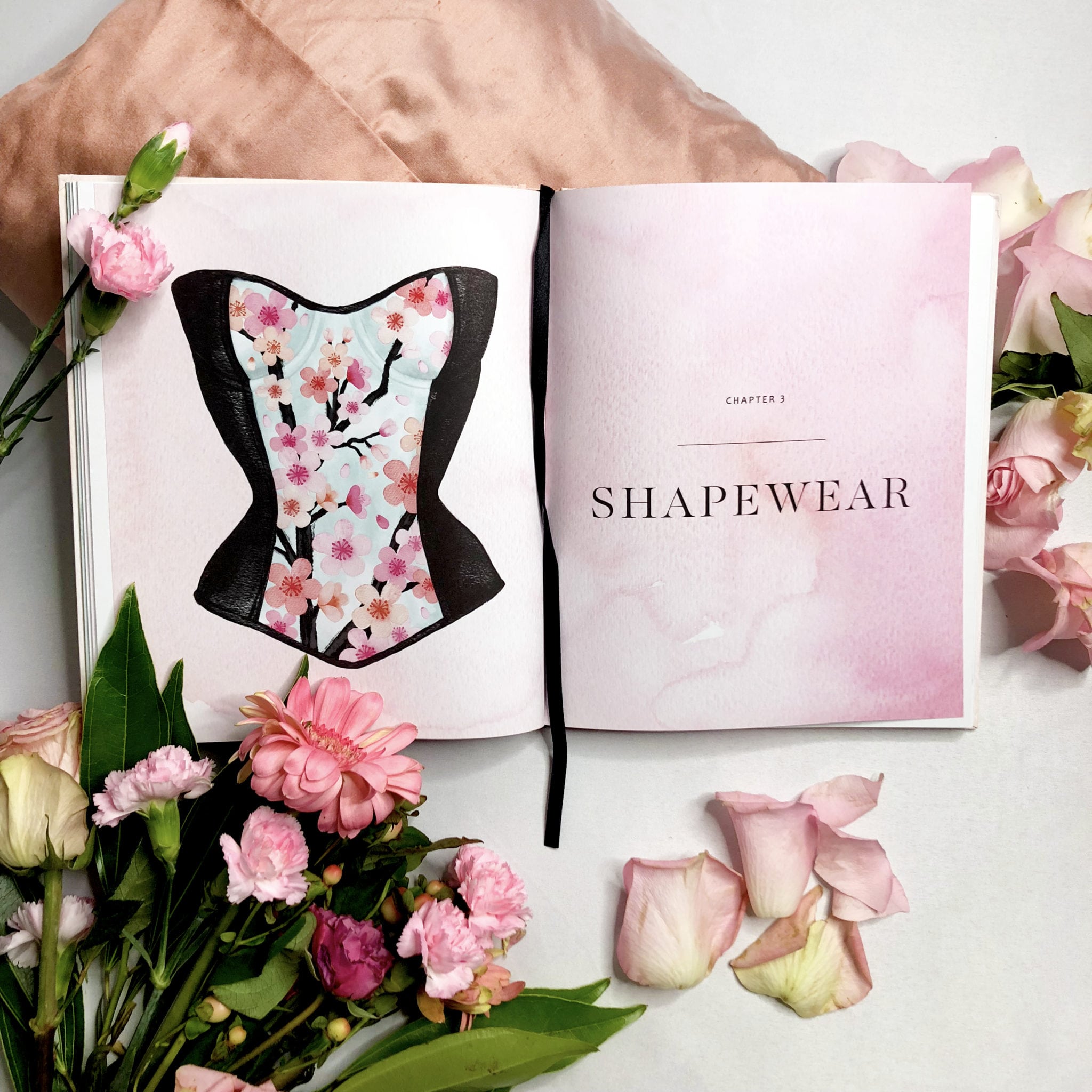 An intro spread from In Intimate Detail that reads Shapewear, alongside a black and floral bustier that may be worn as wedding lingerie