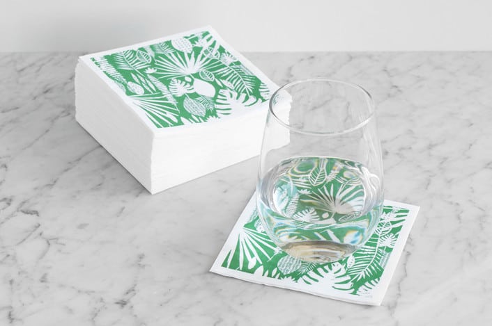 tropical print cocktail napkins styled on a marble surface with a stemless wine glass
