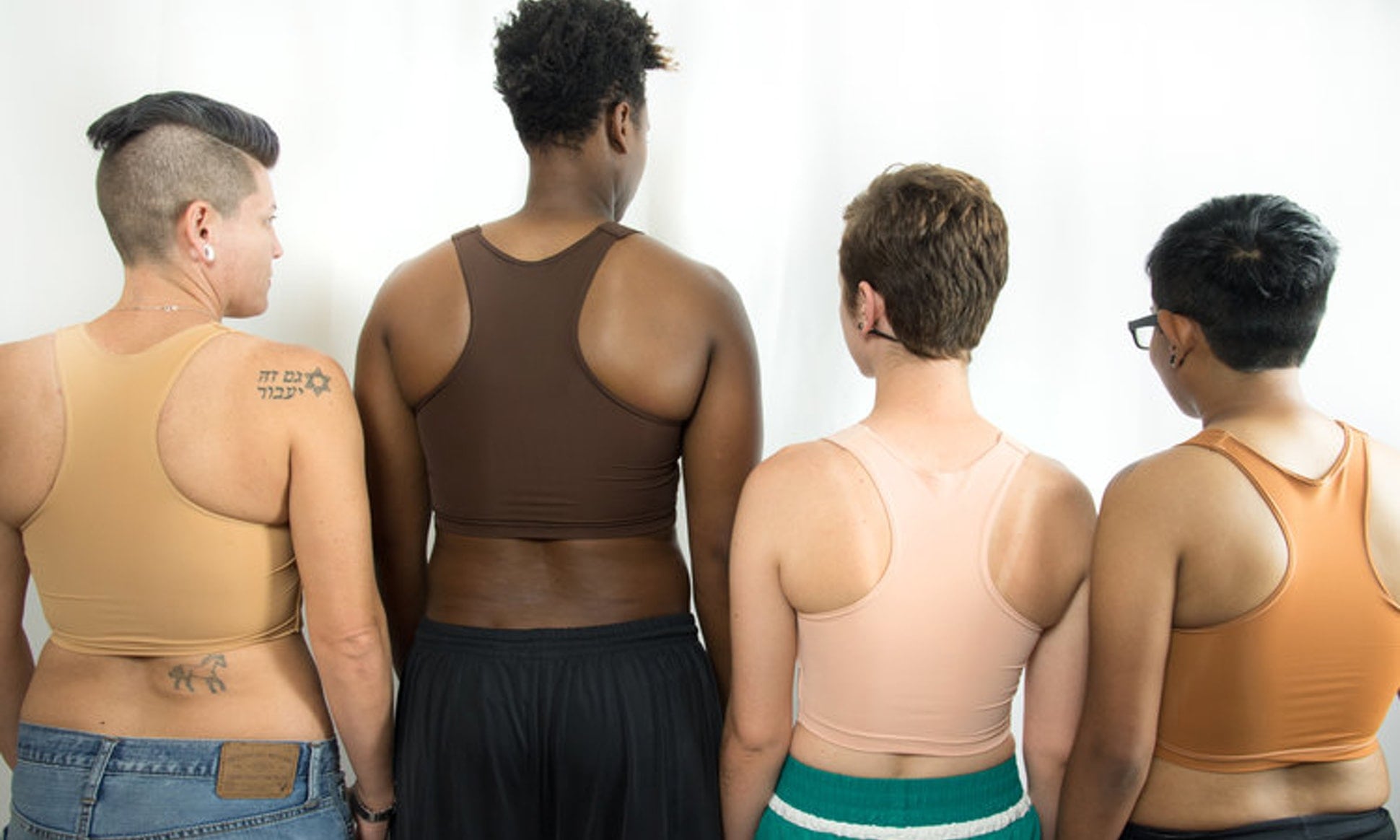 four people with different skin tones and gender identifications with their backs to you wearing skin-tone color binders