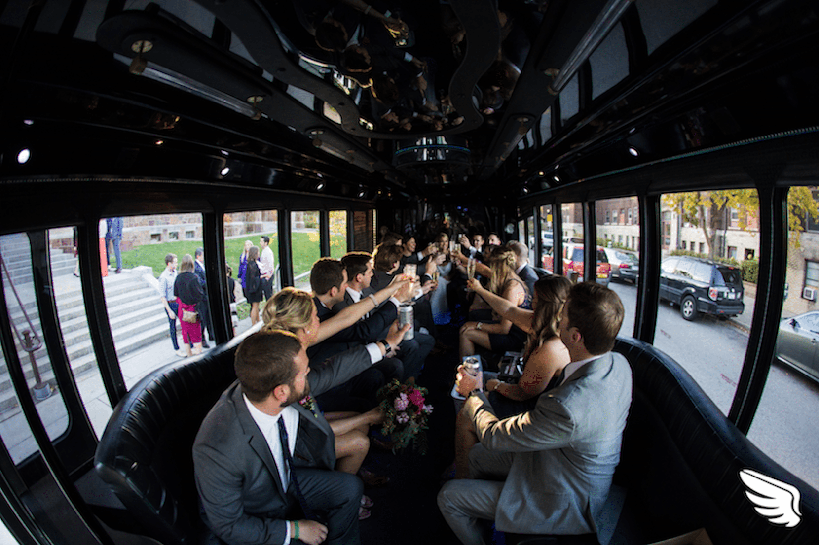 Wedding party on a skeddadle bus, toasting