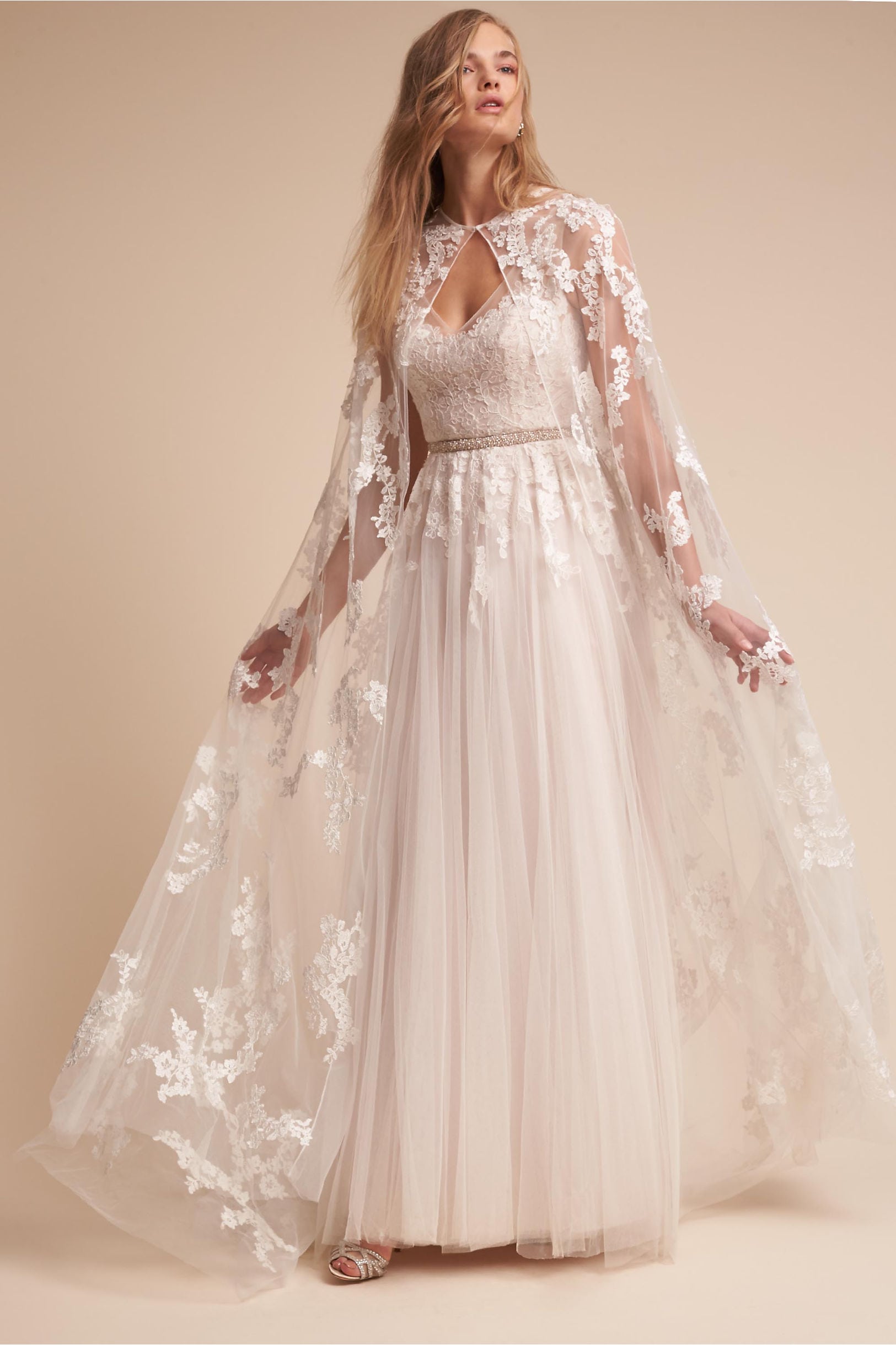 Blonde woman in lace cape and gown in tan room
