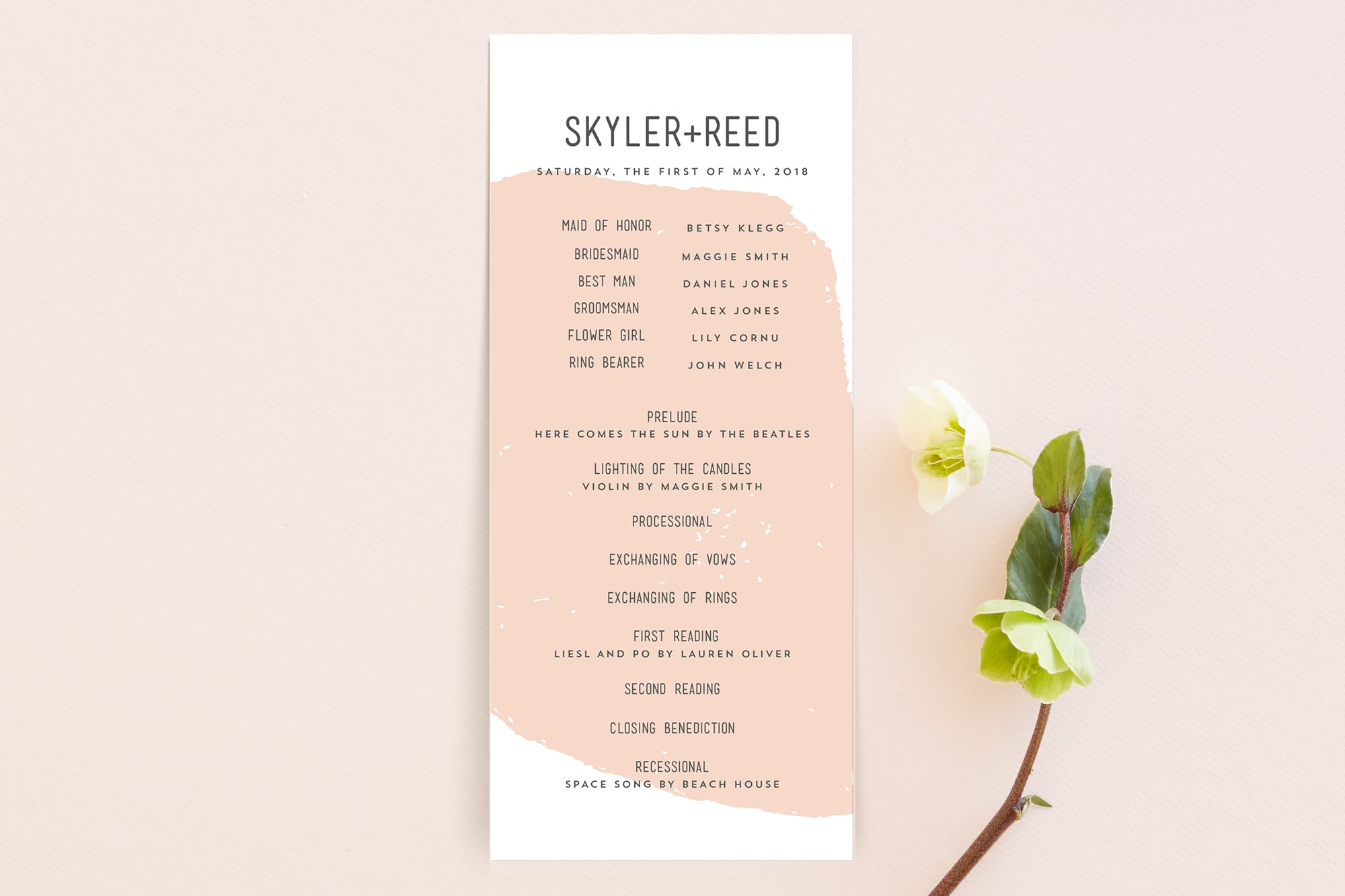 a peach abstract wedding program from minted styled with a single white flower