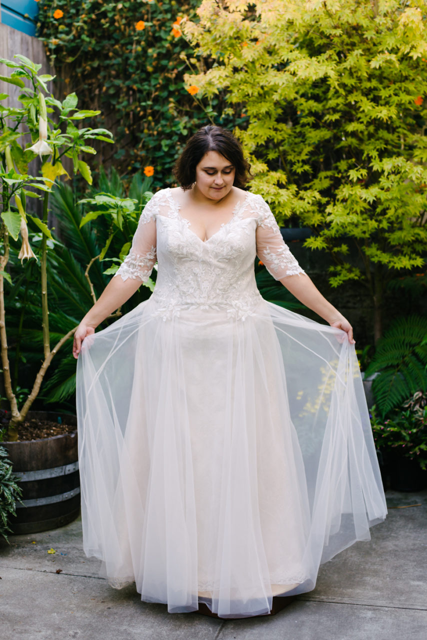 A woman shows off her wedding dress from Lace and Liberty