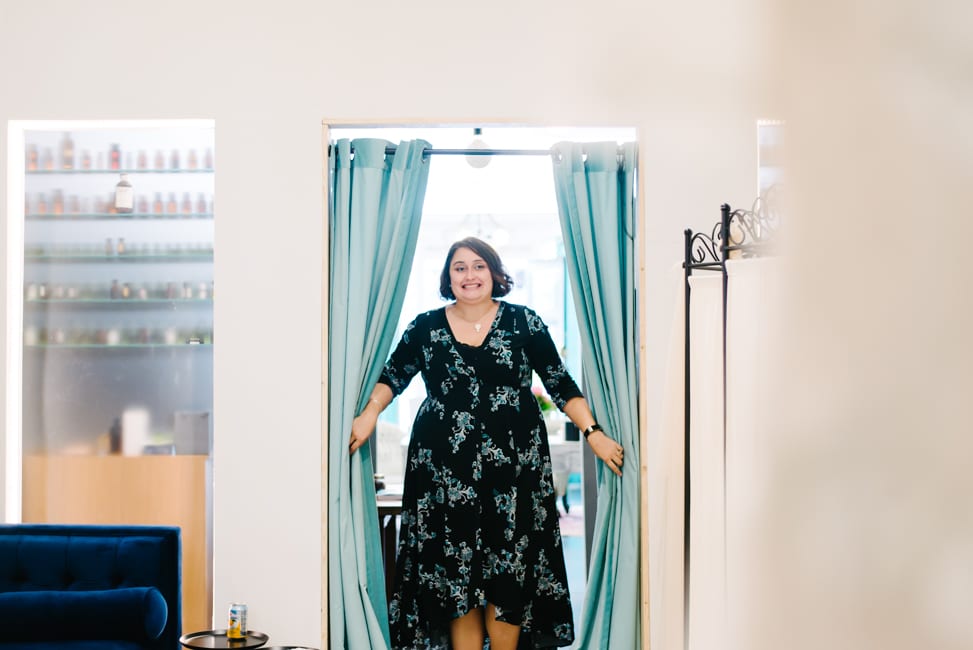 plus size brunette woman walking through the doorway seeing her wedding dress for the first time at Lace and Liberty