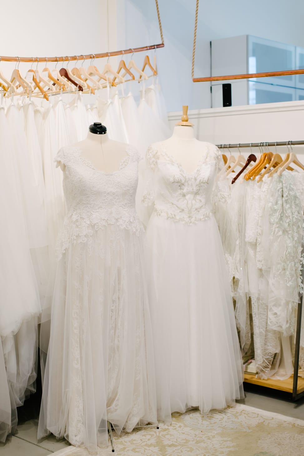 two plus size wedding dresses on dress forms in the Lace and Liberty bridal shop