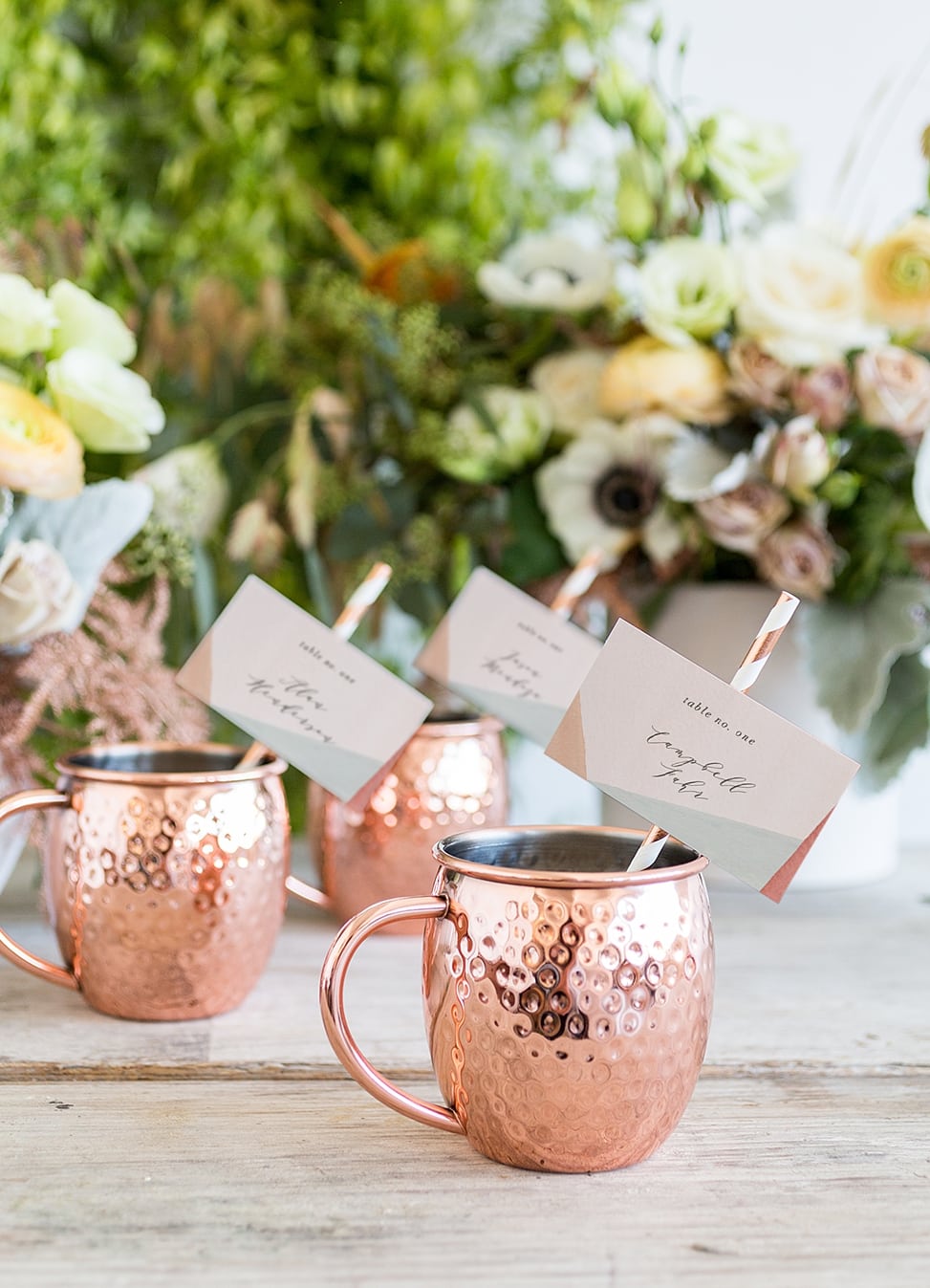 moscow mule cups with paper straws and name cards from minted weddings