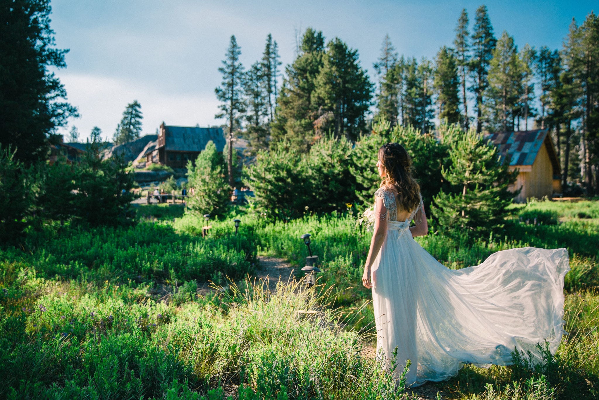 a bride in the green wilderness with her skirt billowing beside her