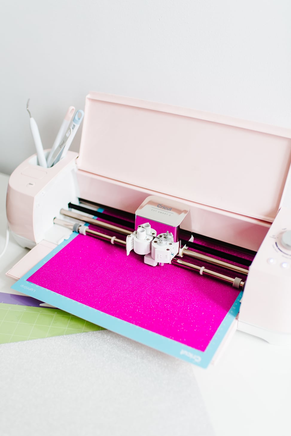 A Cricut Explore Air 2 Machine from Michael's Weddings in action with pink paper