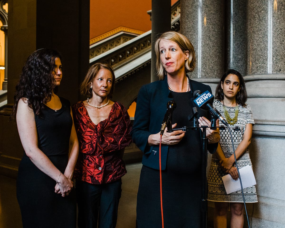 Corey Torpie photo of Zephyr Teachout standing at a microphone with several other women behind her