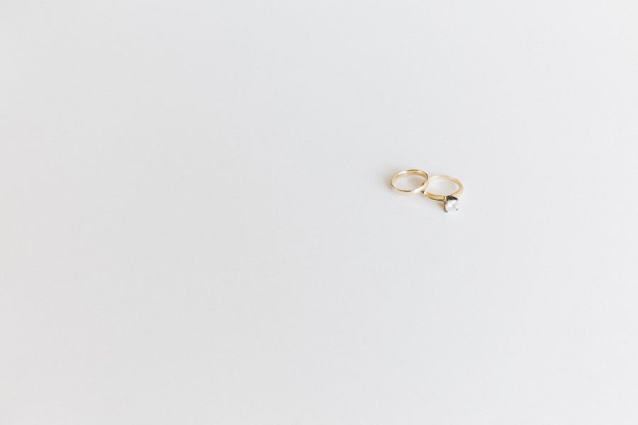 two gold wedding rings on a white surfce