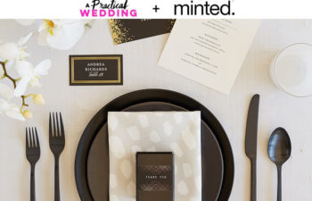 A place setting with a black plate and black flatware with a place card, favor box, and menu from minted. The text "A Practical Wedding + Minted" reads above the image.