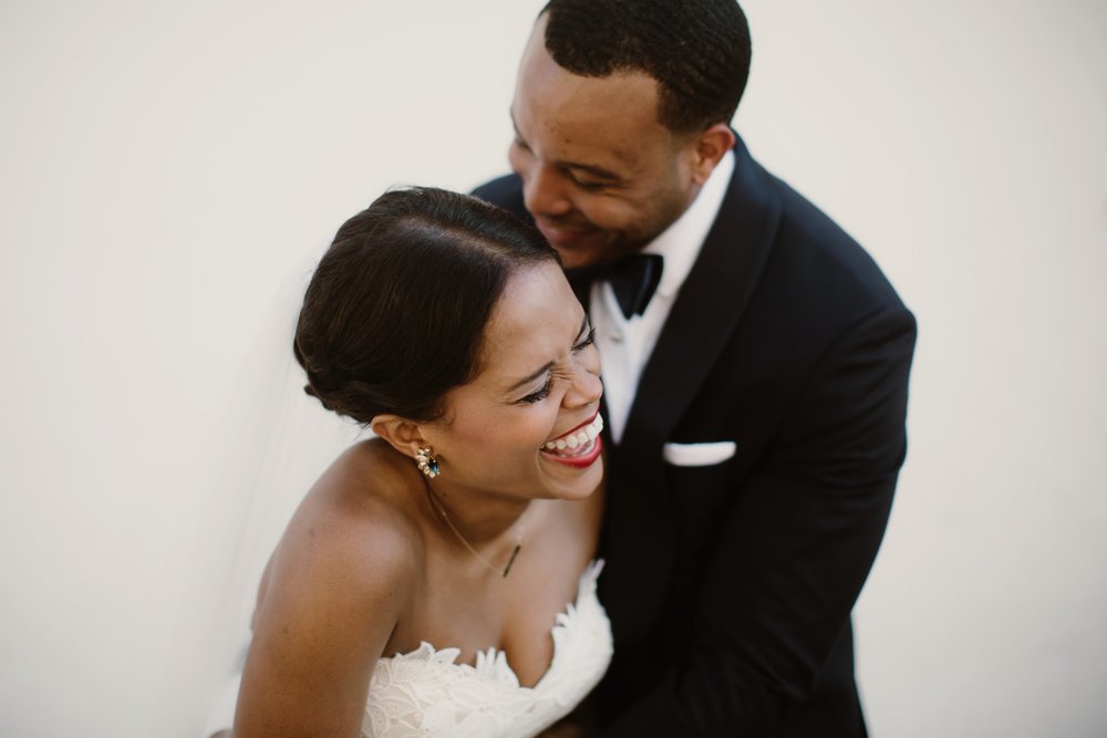 A bride and groom lean into one another as they laugh in a photo by Sarah Gormley
