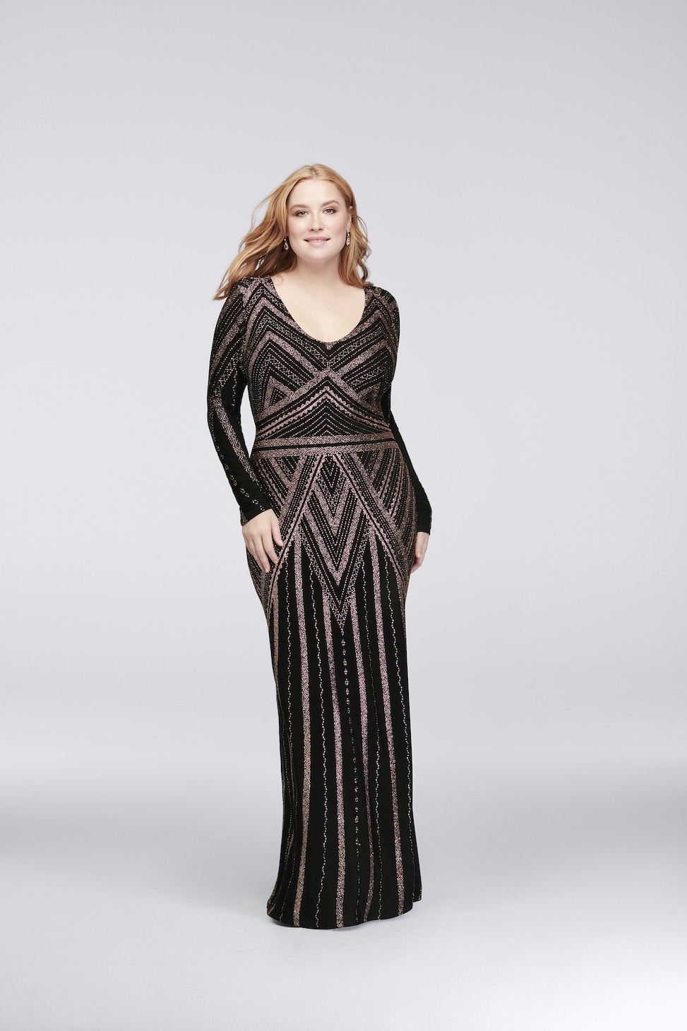 plus size model wearing long sleeve black scoop neck evening gown with art deco geometric details from david's bridal