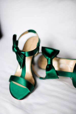 A pair of satin heels in winter wedding colors: emerald
