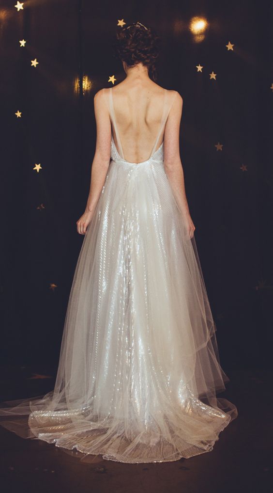 Back of woman in winter wedding colors: a sparkling dress of translucent sequins