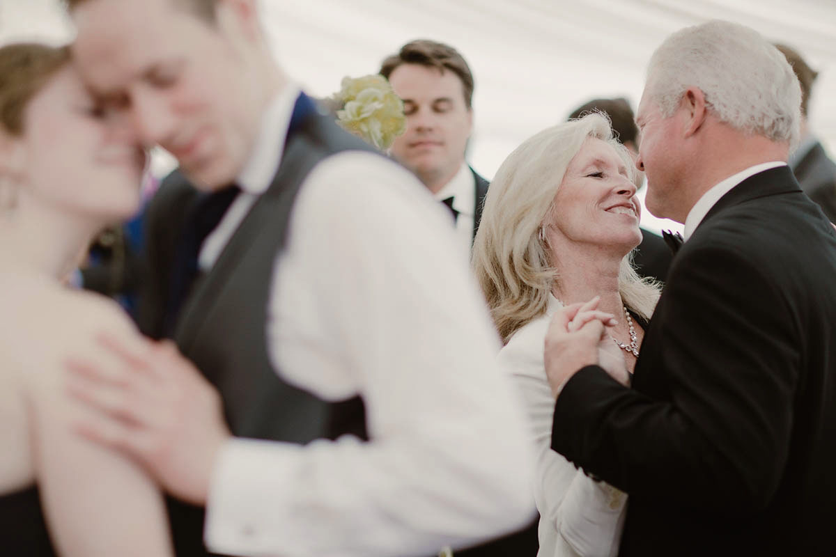 An older couple smiles and looks at each other while dancing, while other couples dance around them in a Sarah Gormley photo