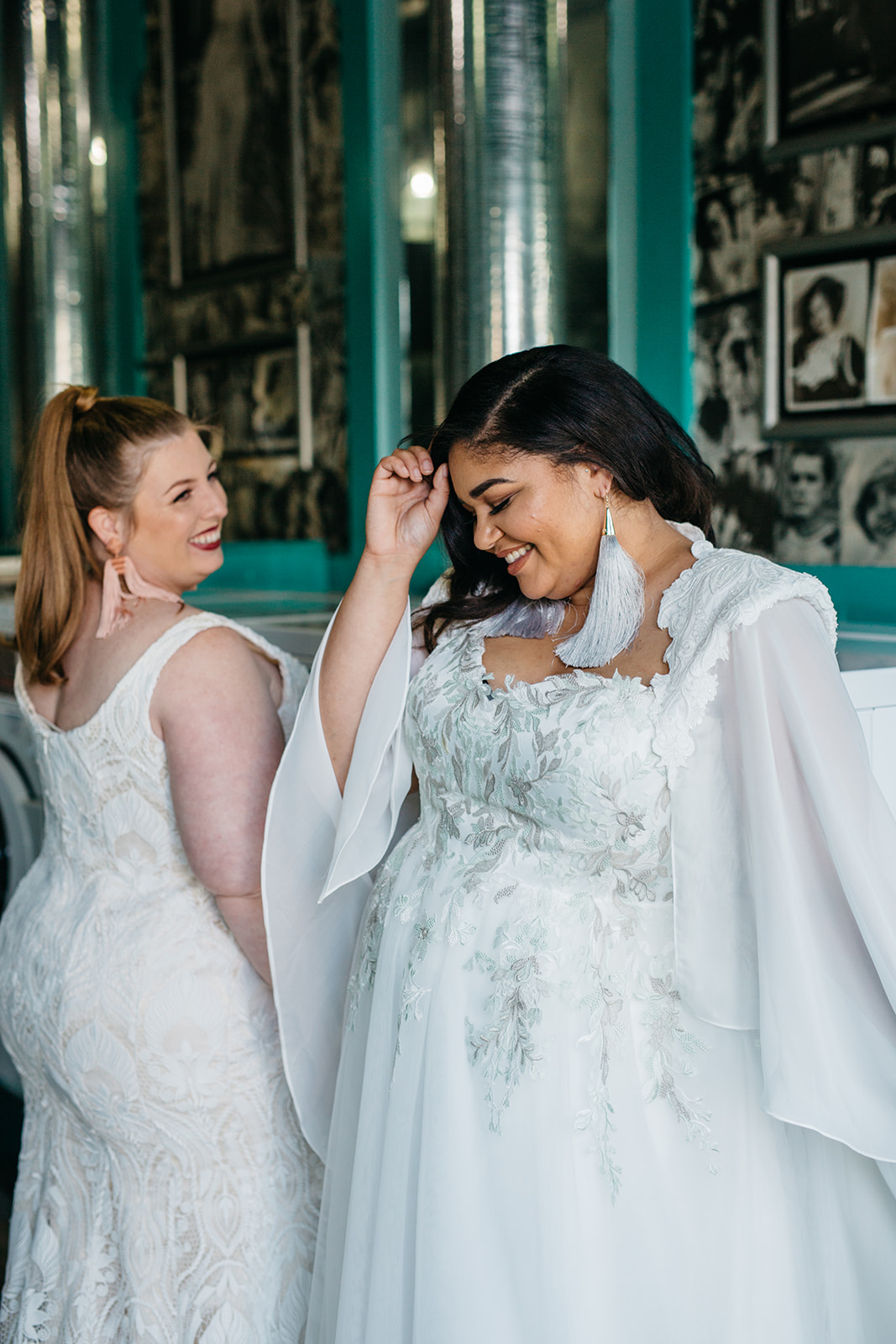 two models laughing wearing plus size wedding gowns from the a practical wedding lace & liberty plus size wedding dress collection