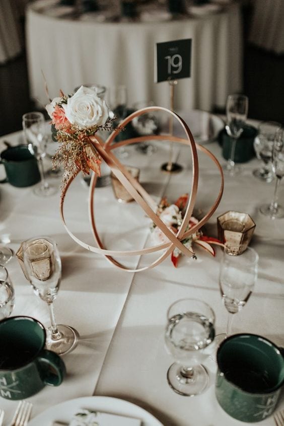 wedding ideas for abstract centerpieces with flowers—a bronze metal orb with coordinating flowers