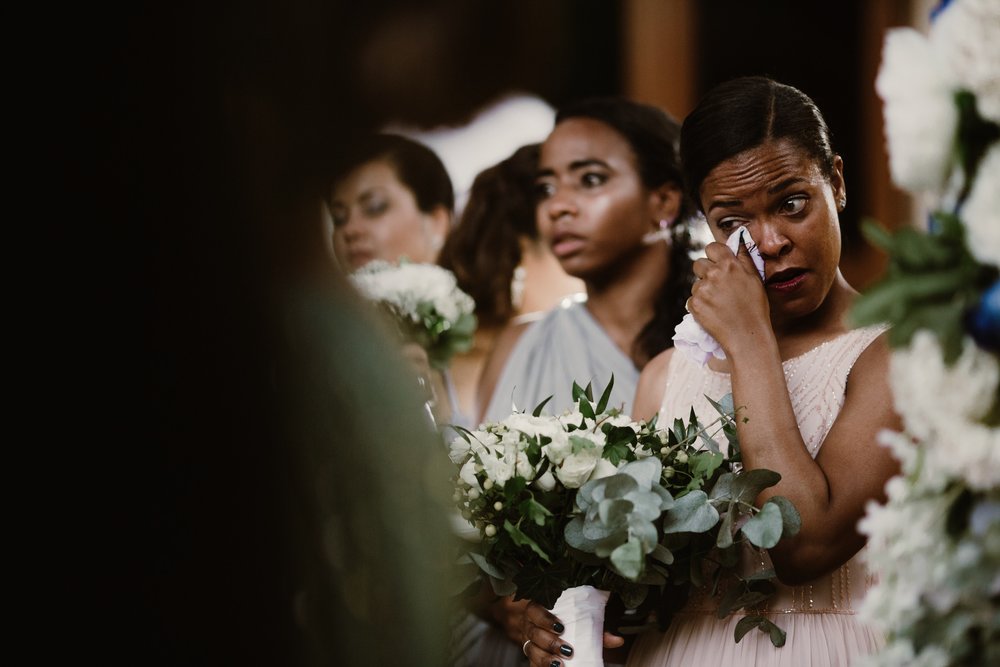 A bridesmaid wipes tears while holding a large green and white bouquet in a Sarah Gormley photo