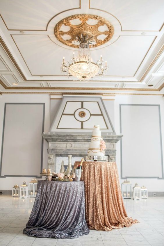 Two dessert tables in winter wedding colors: one with a grey/silver metallic tablecloth and the other with a bronze metallic tablecloth in a large white room with gold, grey, and marble accents