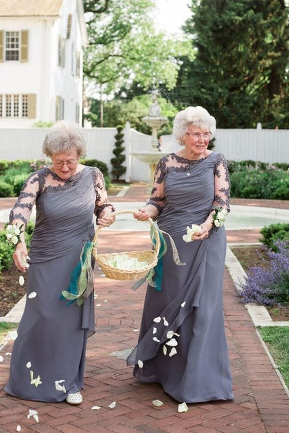 wedding ideas for ceremony attendants—flower grandmas walking down the aisle in matching grey dresses sprinkling white petals as they walk