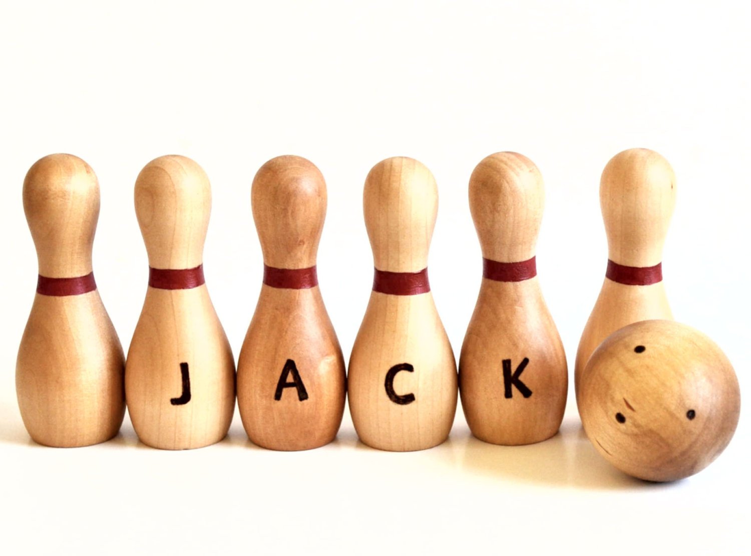 a set of wooden bowling pins with the name Jack painted on the wooden bowling pins