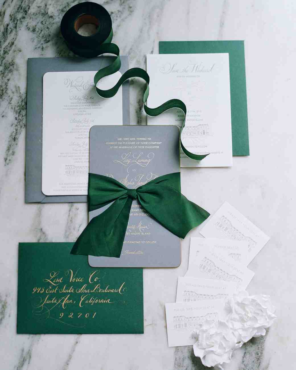 Invitation suite with winter wedding colors green details on marble table