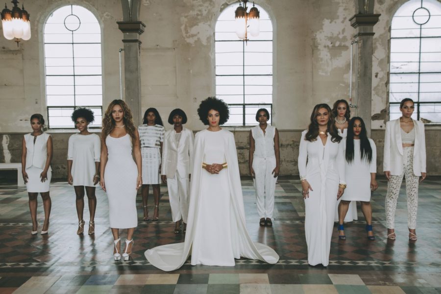 Women in white formal clothes stand together at Solange Knowles wedding