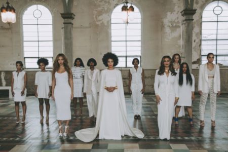 Women in white formal clothes stand together at Solange Knowles wedding