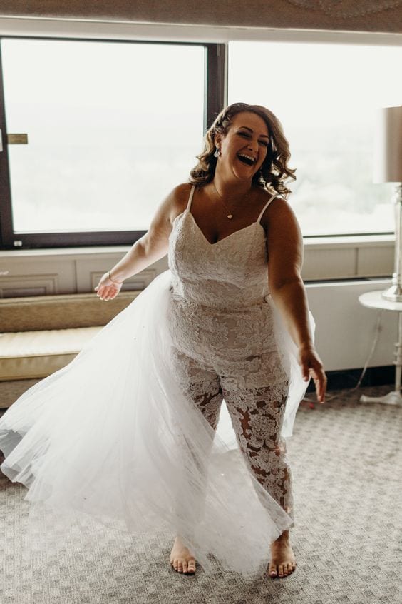 wedding ideas for a bride in a lace jumpsuit, mid twirl, laughing