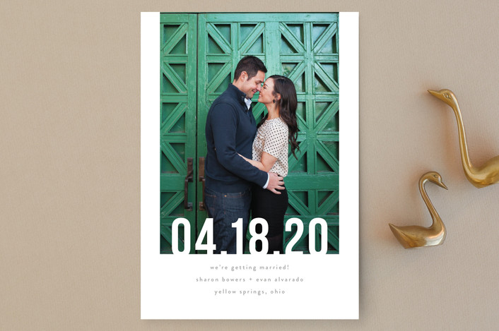 Minted save the date couple in front of green door