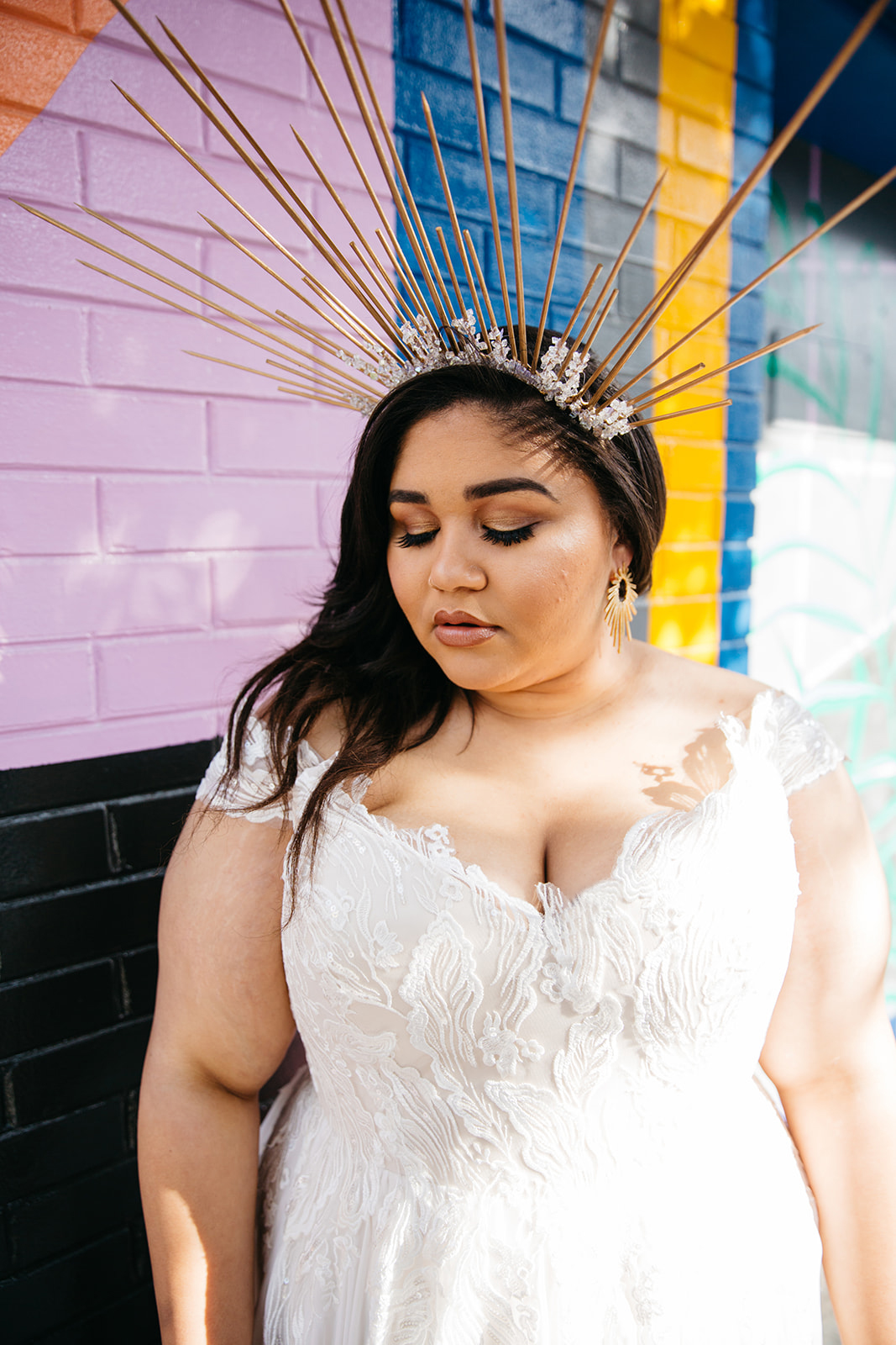 close up of model wearing an off-the-shoulder bohemian lace plus size wedding gown with sheer chiffon from the a practical wedding plus size wedding dress collection
