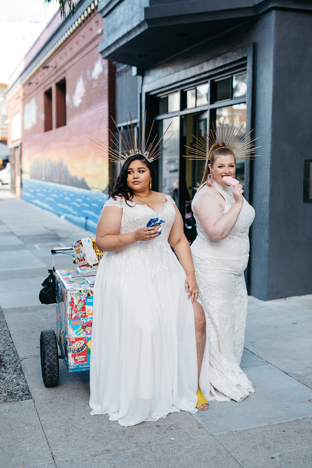 plus size models wearing bohemian plus size wedding dresses from the a practical wedding plus size wedding dress collection sitting on an ice cream cart in san francisco 