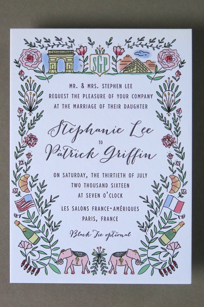 colorful invitation with line drawings of French iconography, and the Louvre, Arc de Triomphe, baguettes, champagne, French and America flags, and pink elephants flat lay of coral and navy-colored wedding invitation suite with affordable letterpress printing by Thomas Printers