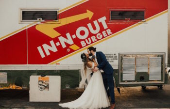 weddings ideas of a couple in a wedding dress and suit kissing in front of in and out truck