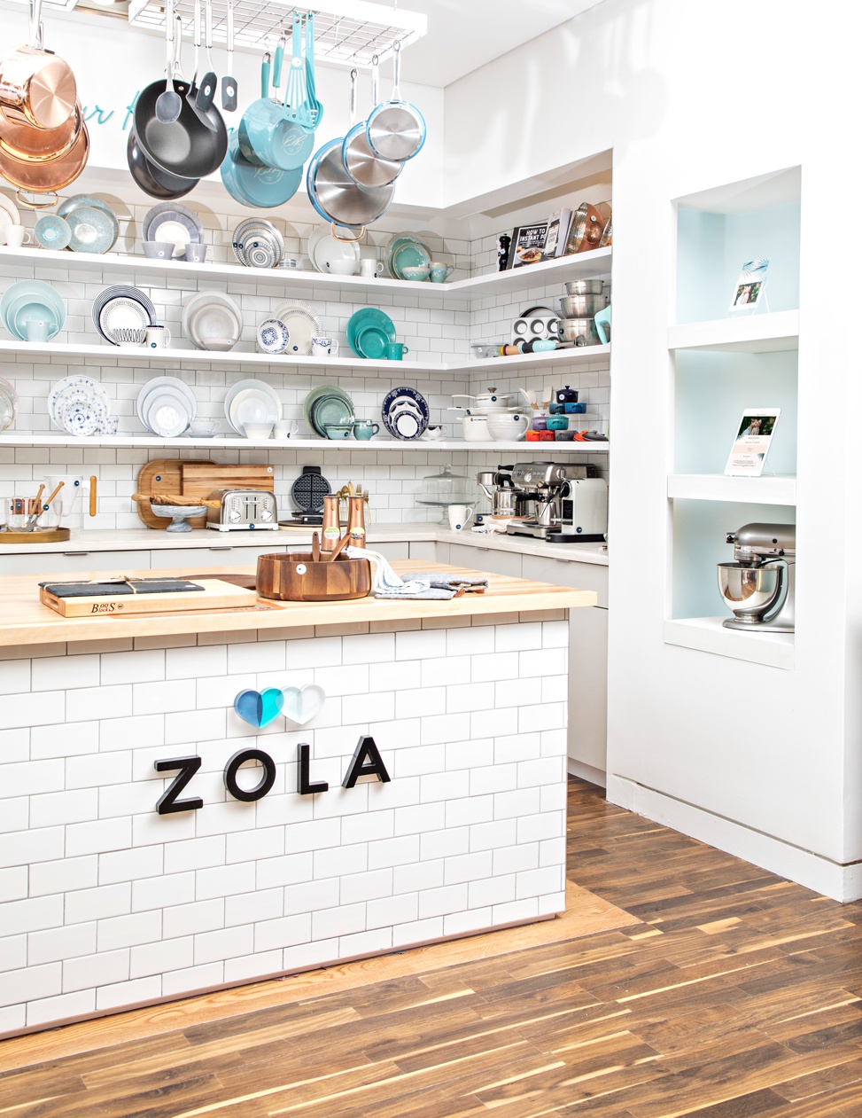 A kitchen full of example plate sets, pots, pans, and other things to put on your wedding registry at the Zola NYC pop-up