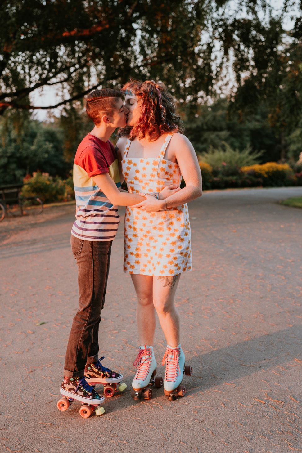 a queer couple kiss for an LGBTQ engagement session while wearing roller skates
