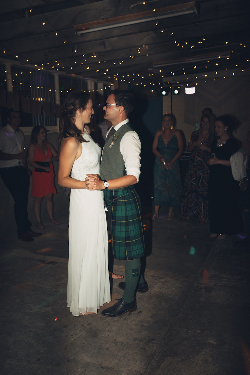 a bride and groom dancing in their carport