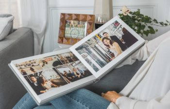 medium close up of a flat lay wedding album open on a woman's lap by Albums Remembered