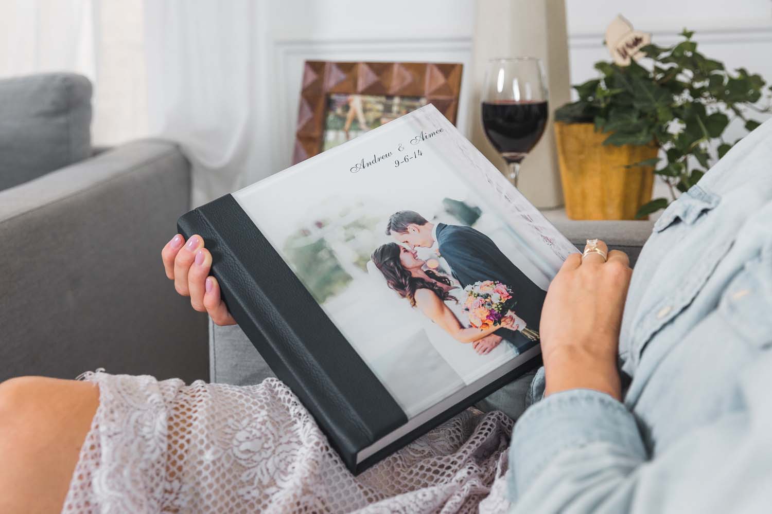 shot of woman holding a flat lay wedding albums by Albums Remembered with a photo cover of a bride and groom