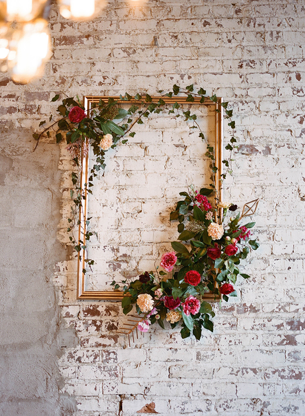 Frame with flower arrangement on a brick wall as an idea for bridal shower decorations