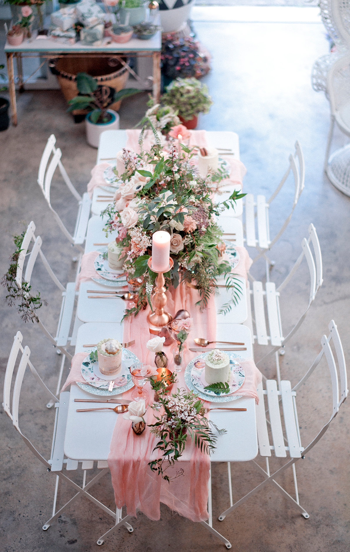A table setting with flowers and a pink table runner as an idea for bridal shower decorations