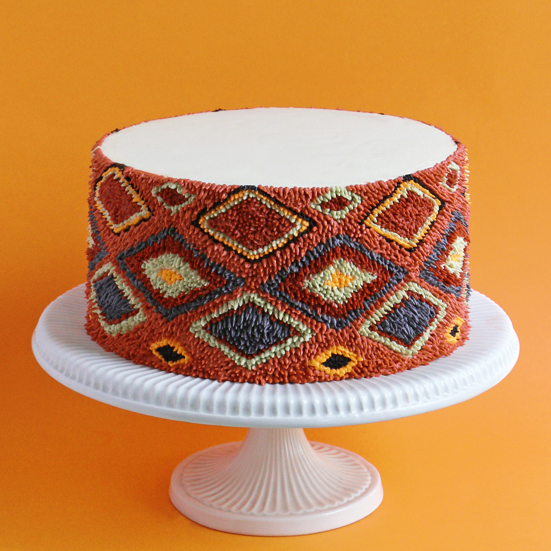 a wedding cake with a textile design in the frosting