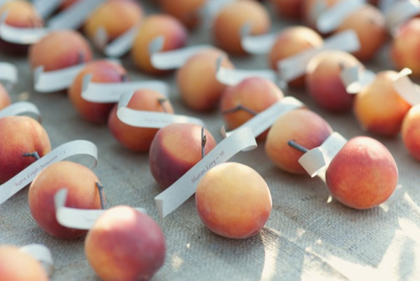 wedding favors - Peaches arranged on table with escort cards.