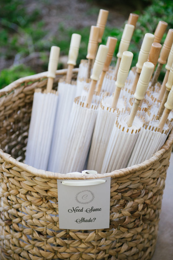White parasols in a basket for bridal shower favors