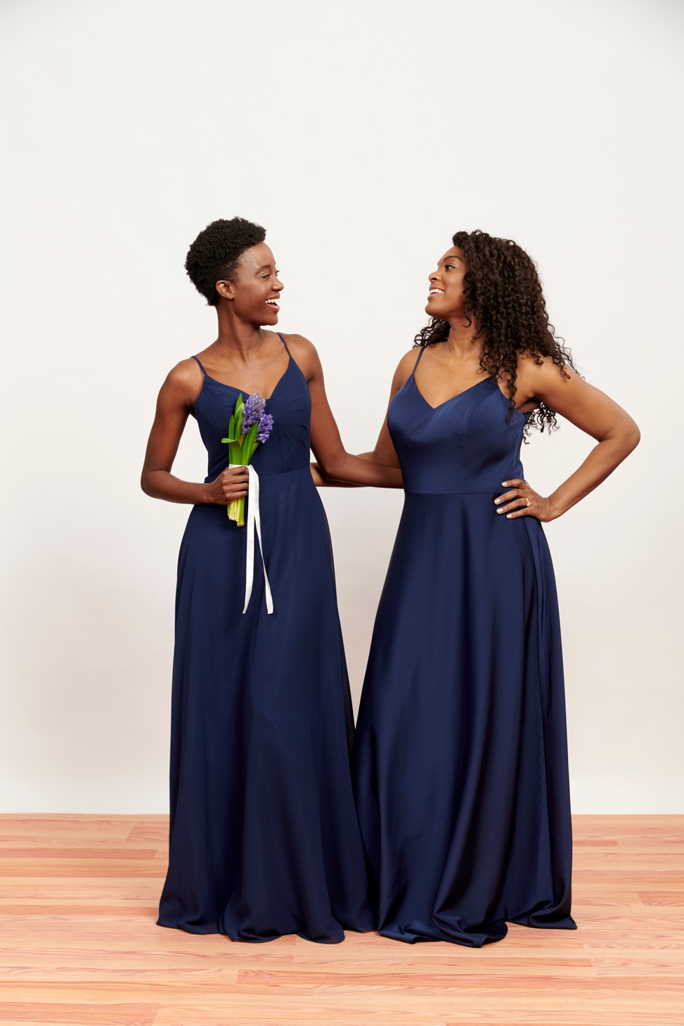 Two women stand in their new Brideside Aura bridesmaid dresses