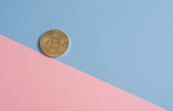 A coin placed on a backdrop of blue and pink