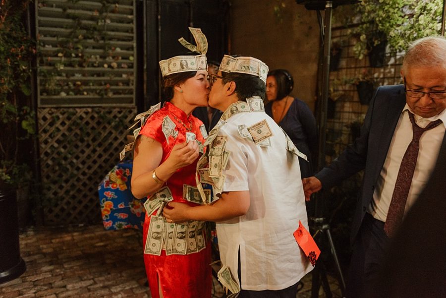 A wedding couple kiss during their 'money' dance